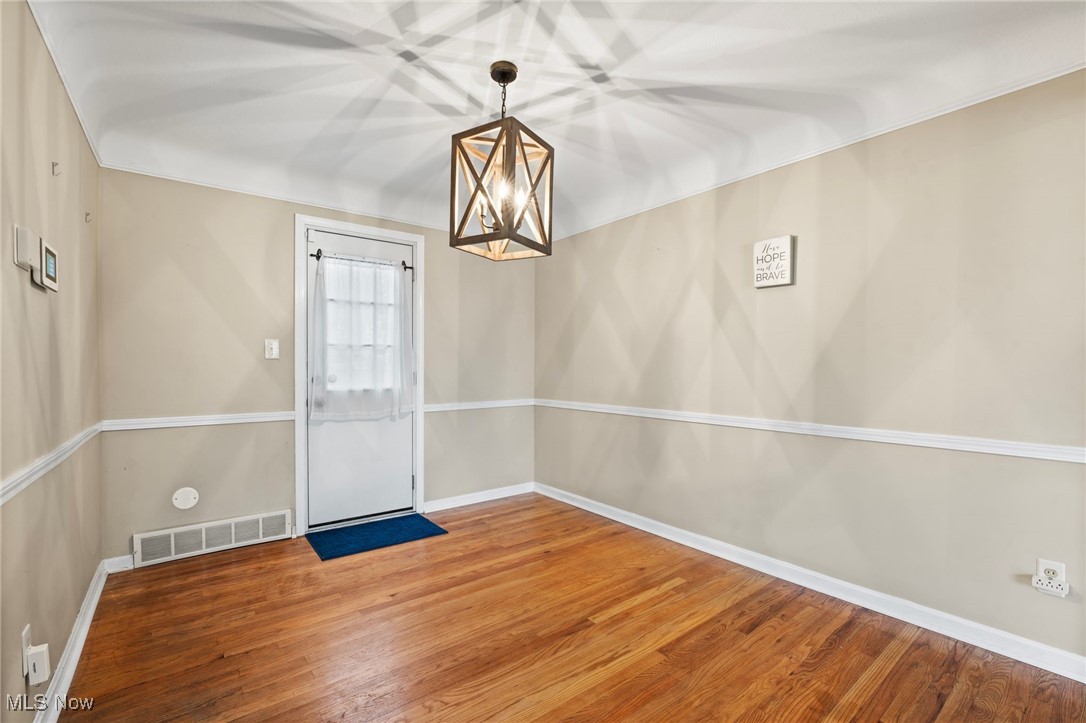 5232 East Farnhurst Road Cleveland, OH 44124 - Photo 9 of 28 Unfurnished room featuring hardwood / wood-style flooring and an inviting chandelier