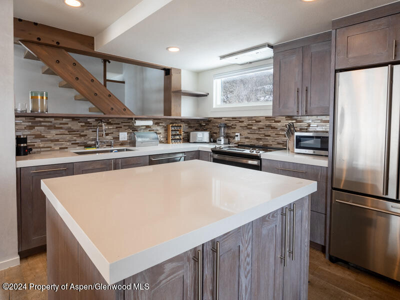 1711 Juniper Hill Road Aspen, CO 81611 - Photo 5 of 19 a kitchen with stainless steel appliances granite countertop a stove a refrigerator a sink and dishwasher with wooden floor