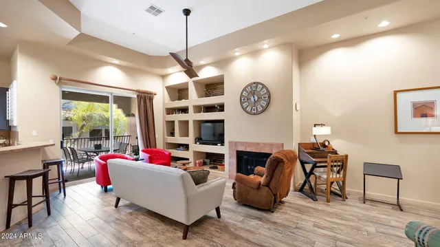 a living room with fireplace furniture and a large window