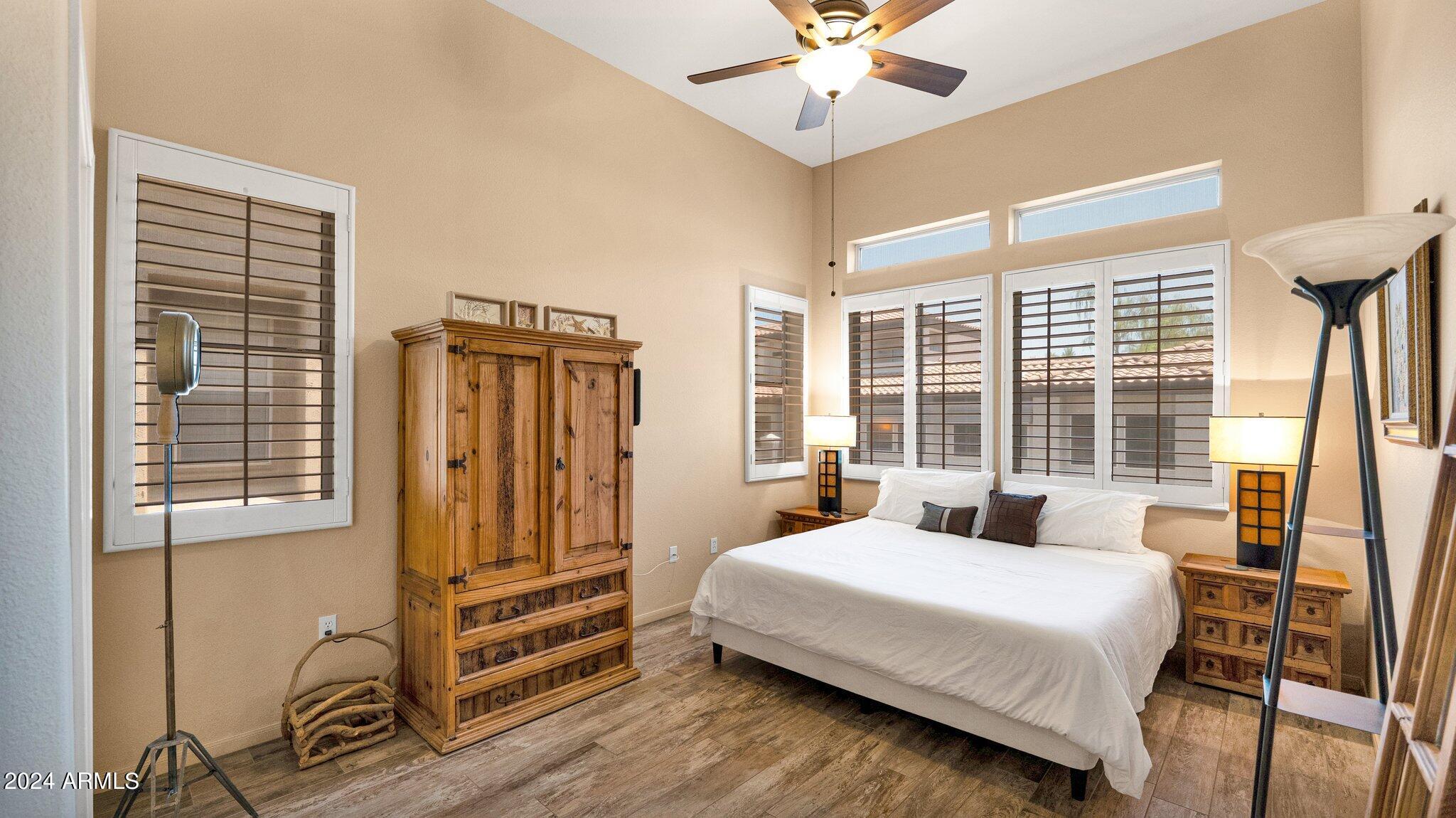 8245 East Bell Road, Unit 207 Scottsdale, AZ 85260 - Photo 12 of 33 a bedroom with a bed and a chandelier