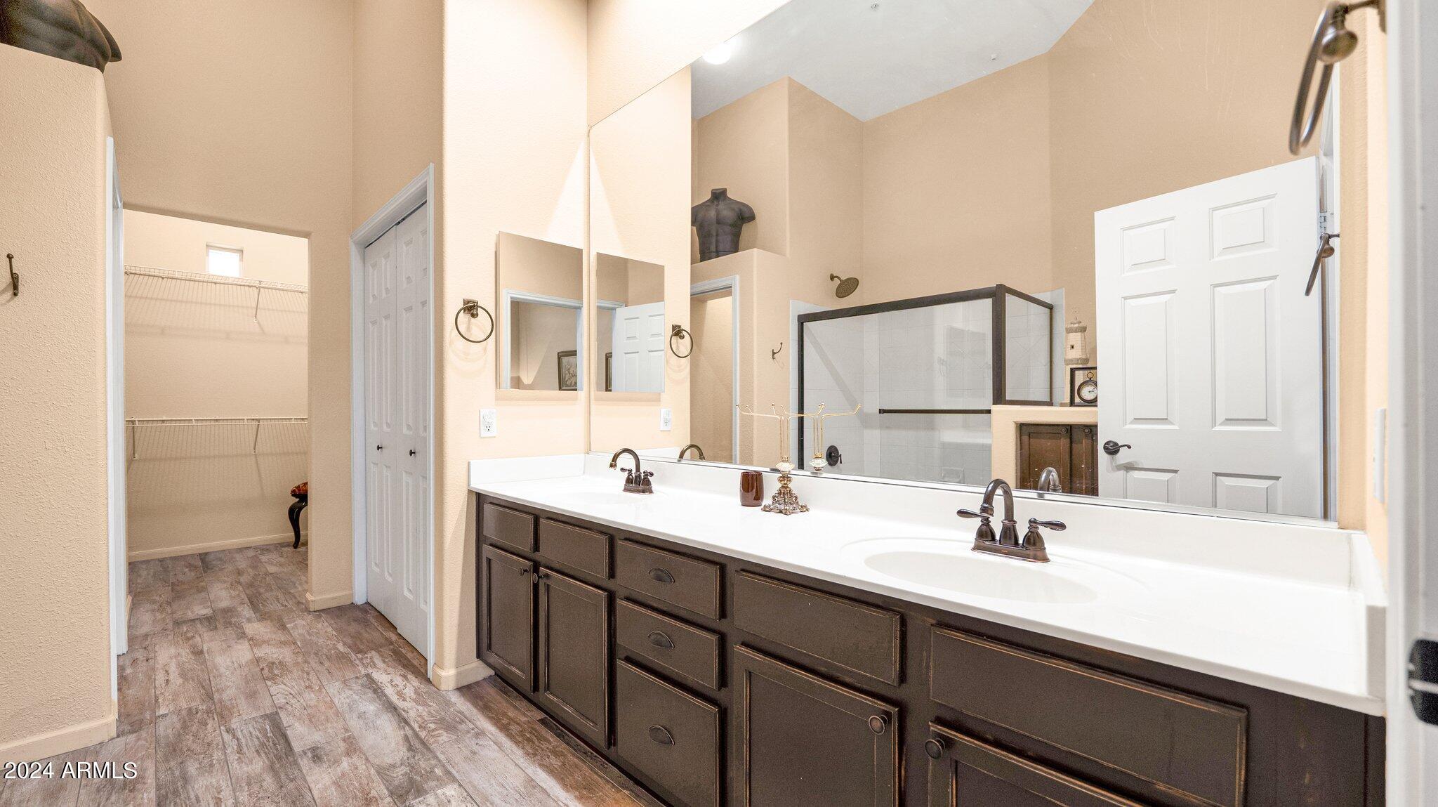8245 East Bell Road, Unit 207 Scottsdale, AZ 85260 - Photo 15 of 33 a bathroom with a double vanity sink a mirror and a shower