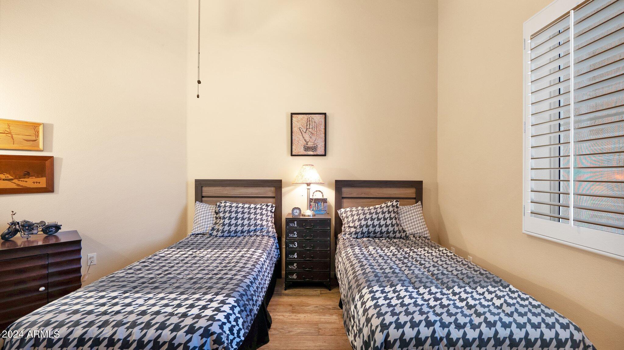 8245 East Bell Road, Unit 207 Scottsdale, AZ 85260 - Photo 20 of 33 a bedroom with two beds and a window