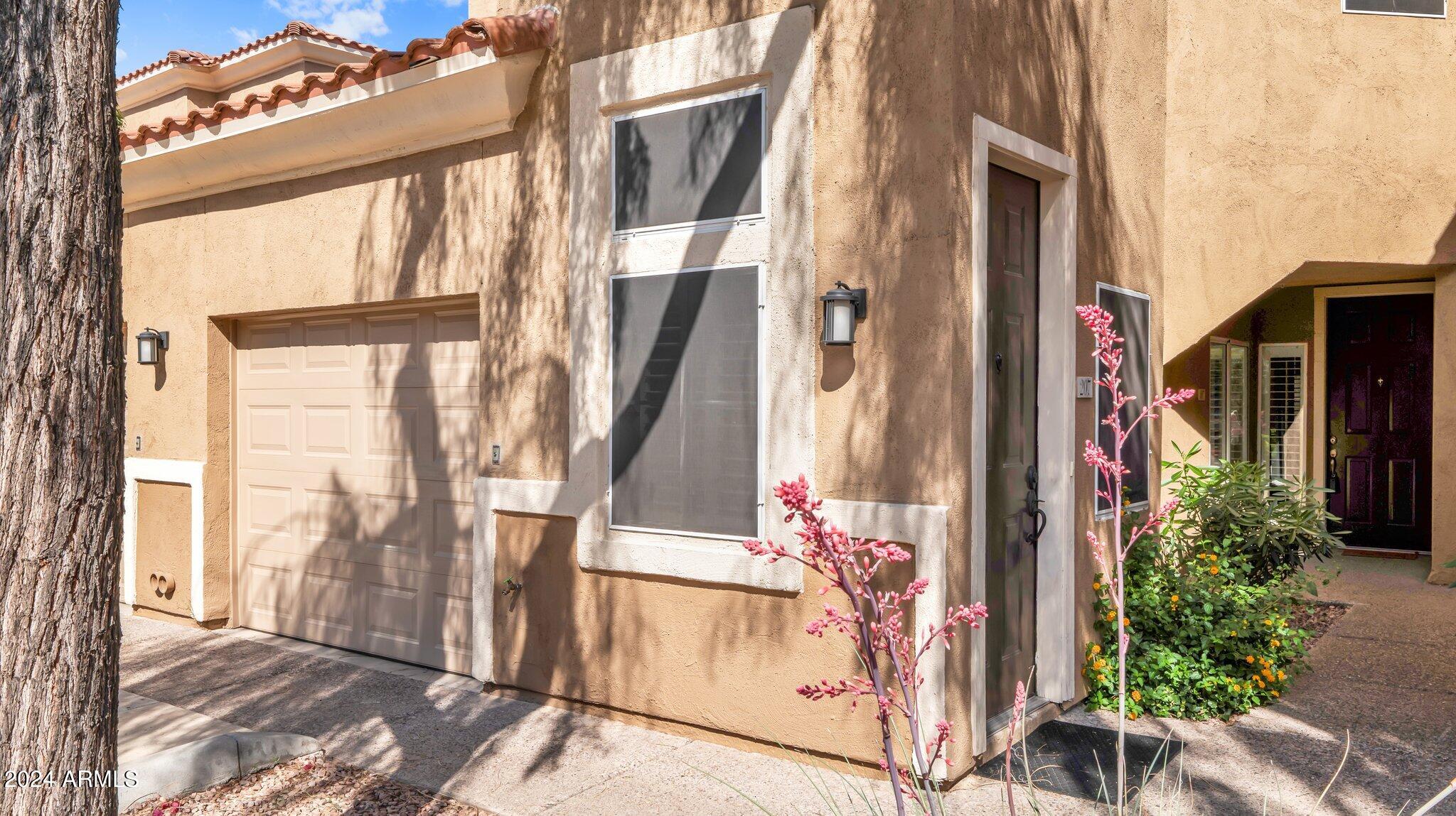 8245 East Bell Road, Unit 207 Scottsdale, AZ 85260 - Photo 2 of 33 a front view of a house with a garden