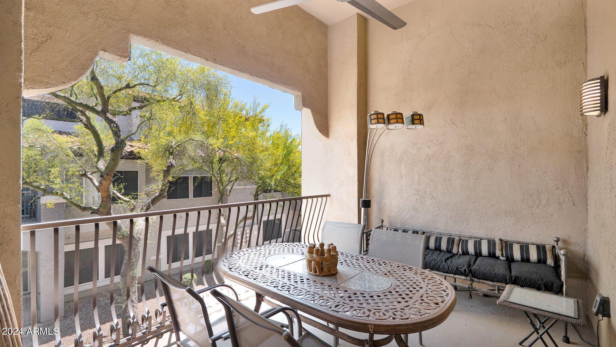 8245 East Bell Road, Unit 207 Scottsdale, AZ 85260 - Photo 23 of 33 a view of a balcony with a table and chairs