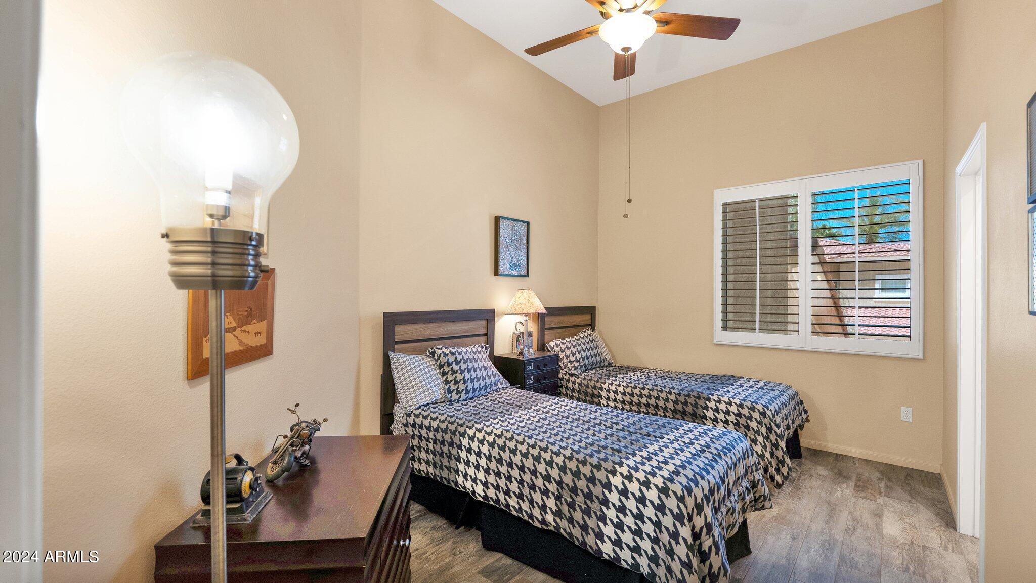 8245 East Bell Road, Unit 207 Scottsdale, AZ 85260 - Photo 29 of 33 a bedroom with a bed and a chandelier