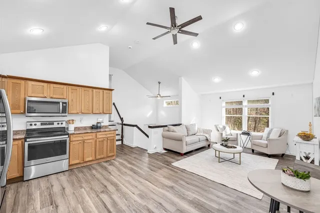 a living room with furniture kitchen and a wooden floor