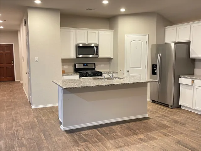 a kitchen with stainless steel appliances a refrigerator sink and microwave