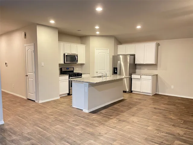 a kitchen with a refrigerator and a stove top oven
