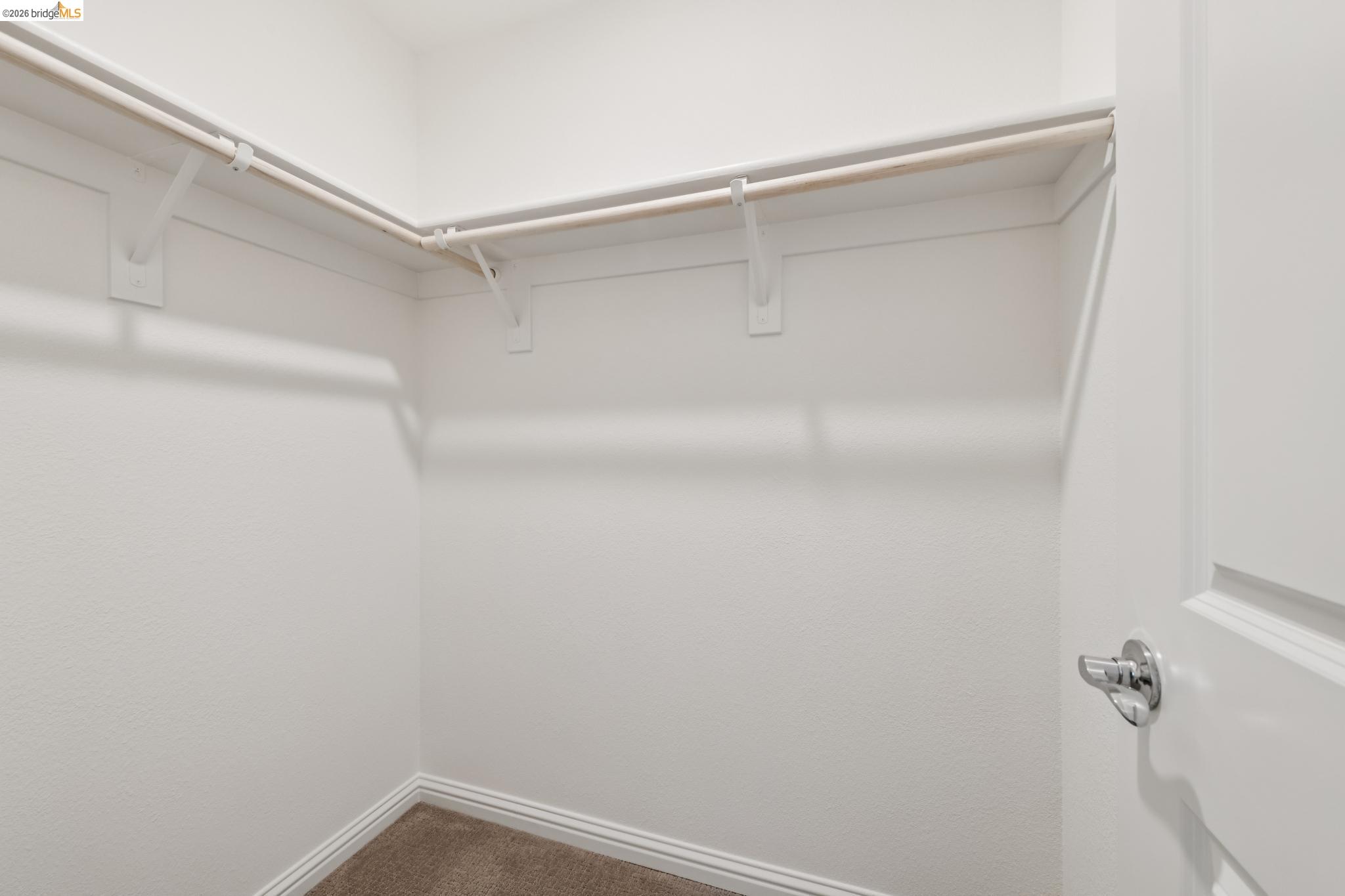 24157 Amaranth Loop Hayward, CA 94541 - Photo 13 of 63 Walk-in closet featuring white painted walls, carpet flooring, baseboard trim, two levels of shelving, and hanging rods