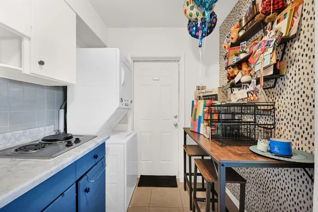 a kitchen with granite countertop a stove and a flat screen tv