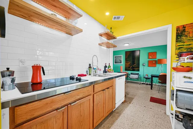 a kitchen that has a lot of cabinets a sink and wooden floor