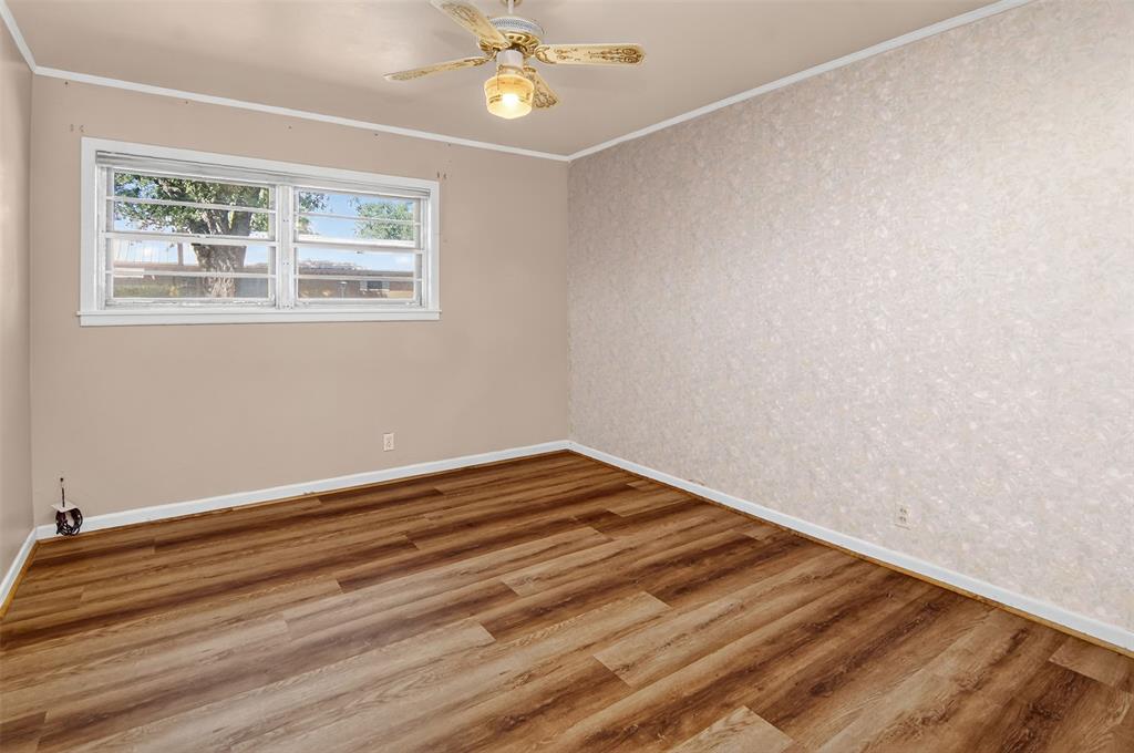 904 Northwest 7th Avenue Mineral Wells, TX 76067 - Photo 18 of 36 Spare room featuring ornamental molding, wallpapered walls, wood finished floors, and a ceiling fan