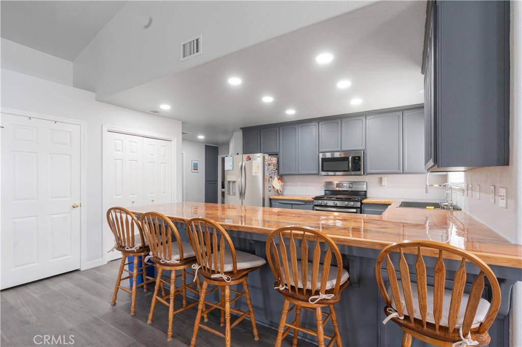 175 South 7th Street Shandon, CA 93461 - Photo 2 of 7 a kitchen with granite countertop a dining table chairs stove refrigerator and cabinets