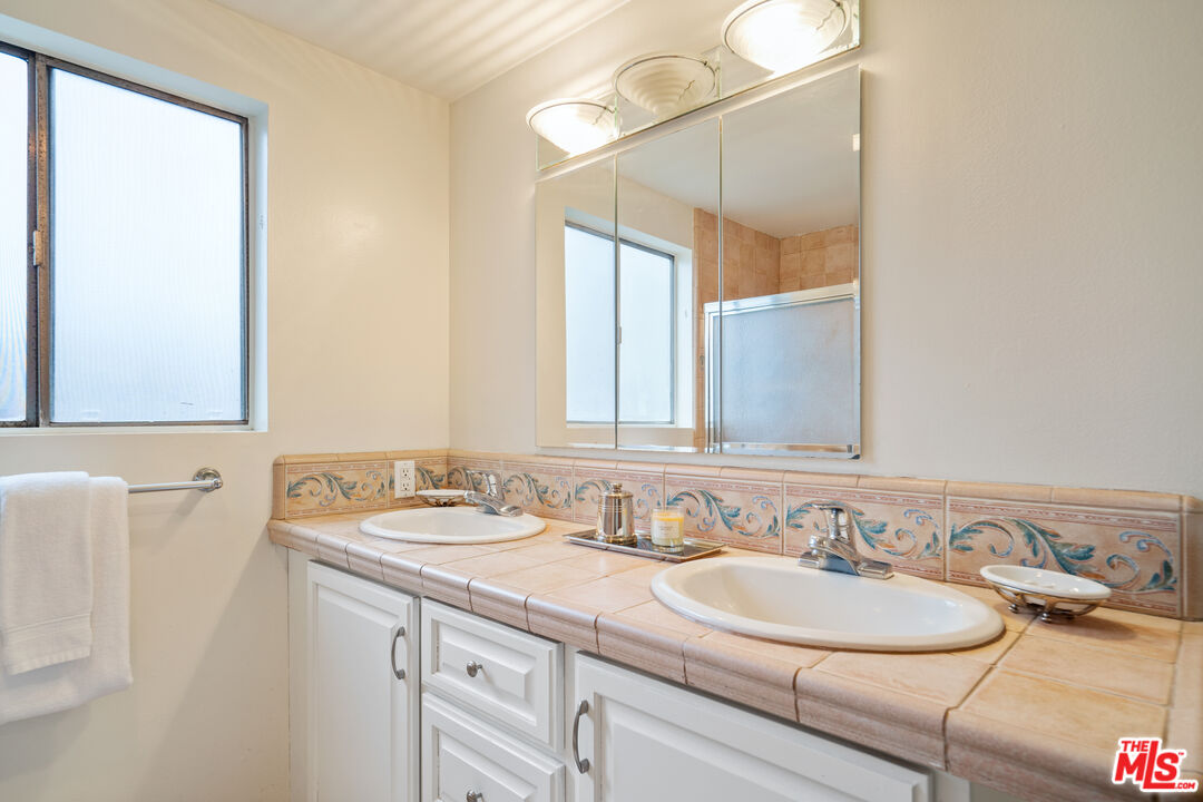 6164 Paseo Cyn Drive Malibu, CA 90265 - Photo 12 of 45 a bathroom with a double vanity sink and a mirror
