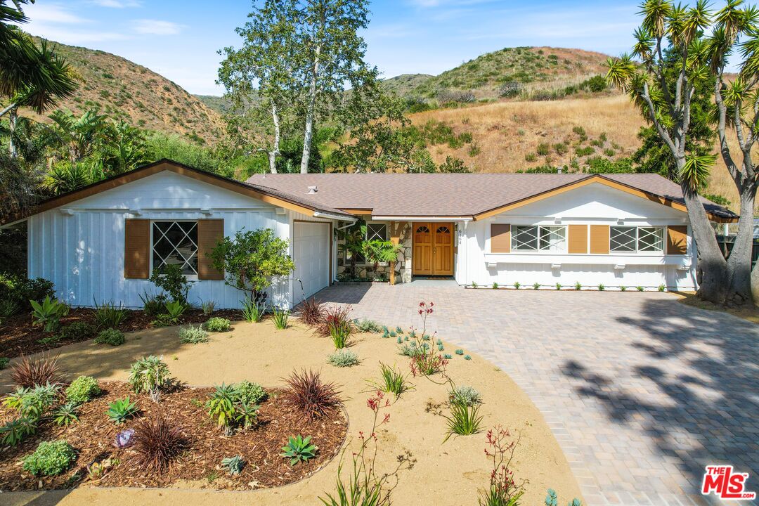 6164 Paseo Cyn Drive Malibu, CA 90265 - Photo 4 of 45 a front view of a house with a yard and green space