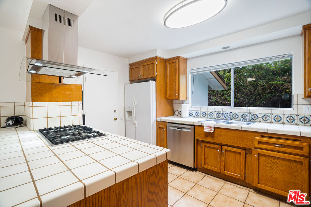 6164 Paseo Cyn Drive Malibu, CA 90265 - Photo 8 of 45 a kitchen with stainless steel appliances a stove a sink and a refrigerator