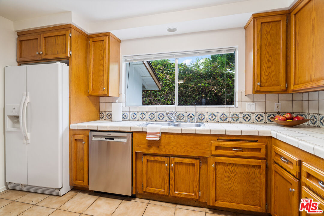 6164 Paseo Cyn Drive Malibu, CA 90265 - Photo 9 of 45 a kitchen with stainless steel appliances granite countertop a refrigerator and a sink