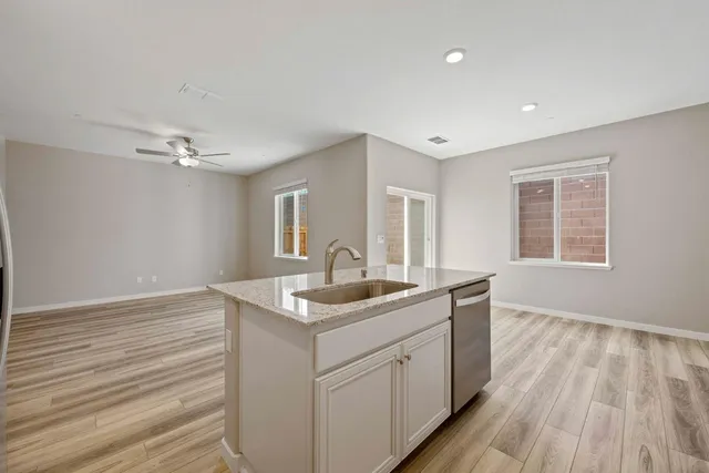 a kitchen with a sink cabinets and wooden floor