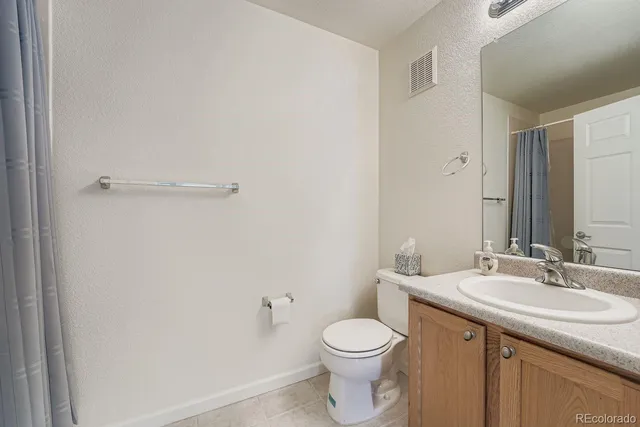 a bathroom with a toilet a sink and a mirror