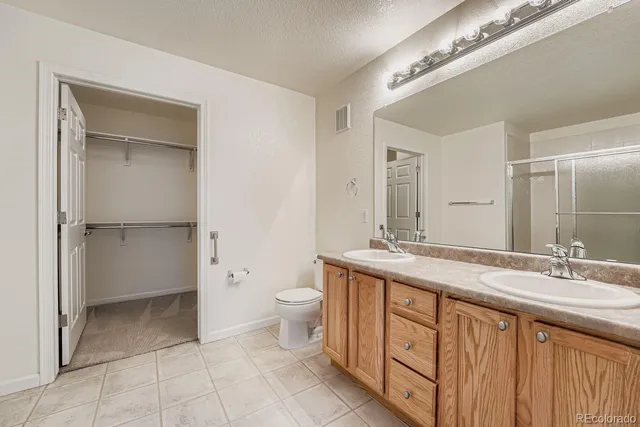 a bathroom with a granite countertop sink a toilet and a mirror