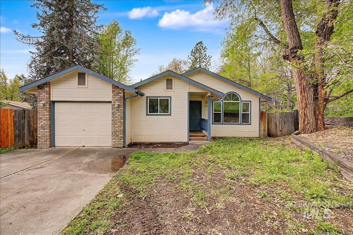 Single story home with driveway and a garage