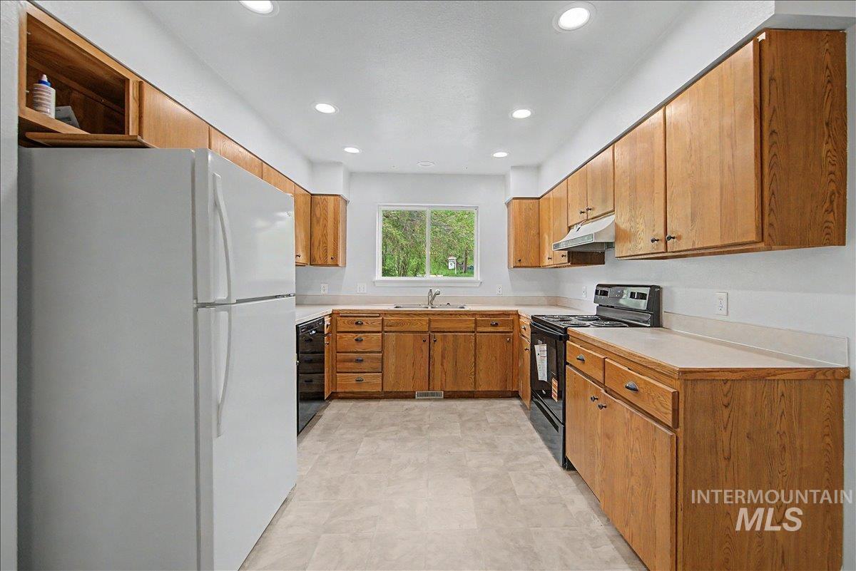 2501 West Hill Road Boise, ID 83702 - Photo 11 of 31 Kitchen with black appliances, light countertops, wood finish cabinets, and recessed lighting