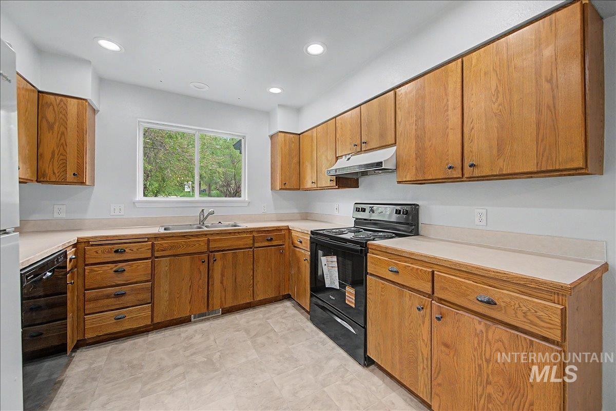 2501 West Hill Road Boise, ID 83702 - Photo 12 of 31 Kitchen featuring black appliances, wood finish cabinetry, light countertops, and recessed lighting