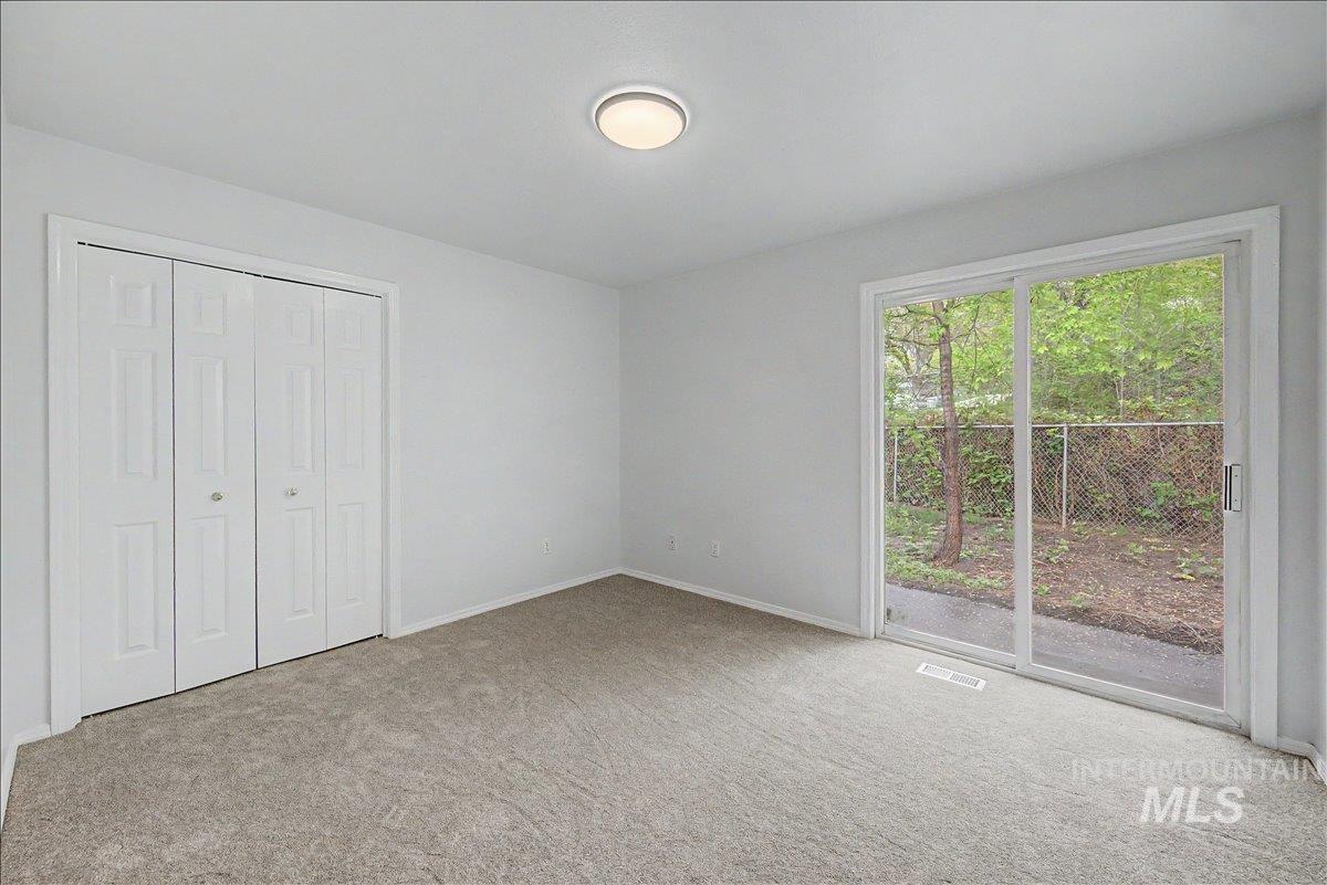 2501 West Hill Road Boise, ID 83702 - Photo 13 of 31 Unfurnished bedroom featuring access to exterior, light colored carpet, and a closet
