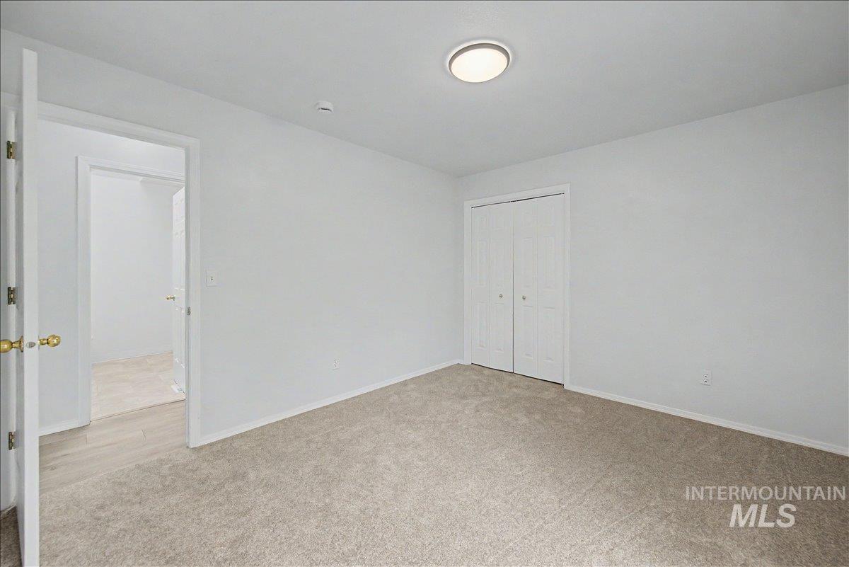 2501 West Hill Road Boise, ID 83702 - Photo 14 of 31 Unfurnished bedroom featuring light colored carpet and a closet