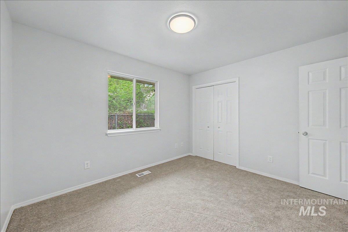 2501 West Hill Road Boise, ID 83702 - Photo 19 of 31 Unfurnished bedroom featuring light carpet and a closet