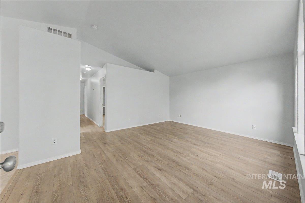2501 West Hill Road Boise, ID 83702 - Photo 4 of 31 Spare room featuring light wood-style floors and lofted ceiling