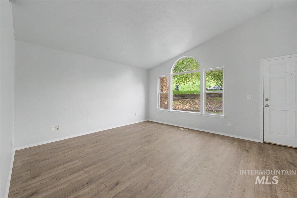 2501 West Hill Road Boise, ID 83702 - Photo 5 of 31 Unfurnished room featuring lofted ceiling and wood finished floors