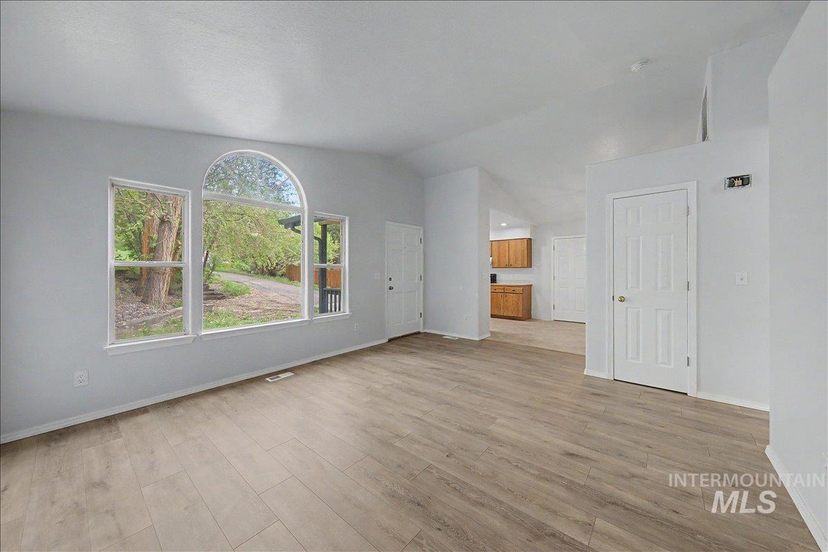2501 West Hill Road Boise, ID 83702 - Photo 6 of 31 Unfurnished living room with vaulted ceiling and light wood-type flooring