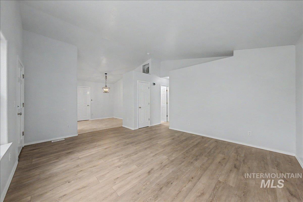 2501 West Hill Road Boise, ID 83702 - Photo 7 of 31 Empty room featuring light wood-style floors and vaulted ceiling
