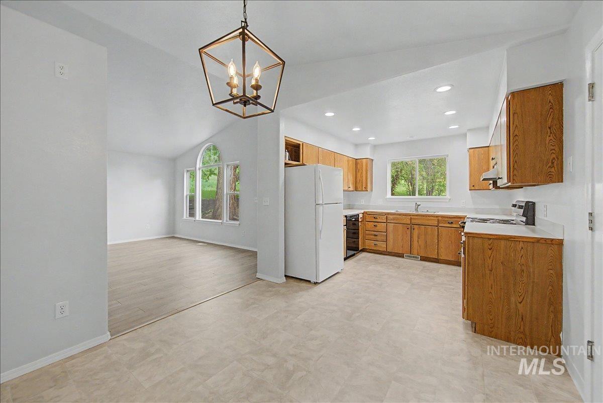 2501 West Hill Road Boise, ID 83702 - Photo 10 of 31 Kitchen with light countertops, freestanding refrigerator, wood finish cabinets, hanging lights, and light floors