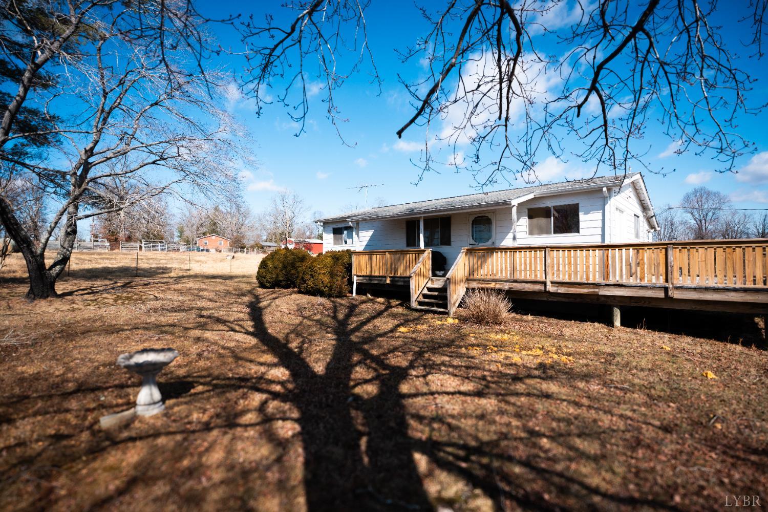 1228 Clover Creek Road Huddleston, VA 24104 - Photo 25 of 25 a view of a house with large trees in the background