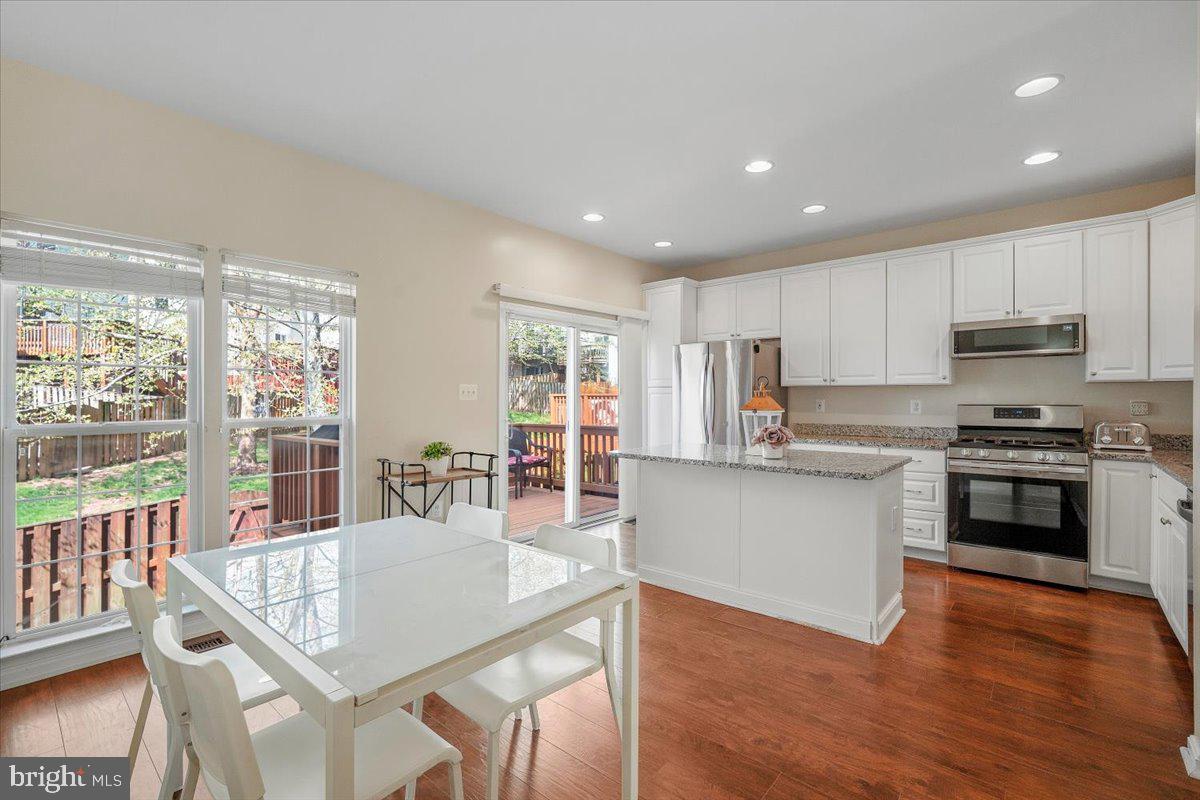 22019 Box Car Square Sterling, VA 20166 - Photo 2 of 31 a kitchen with a table chairs microwave and cabinets