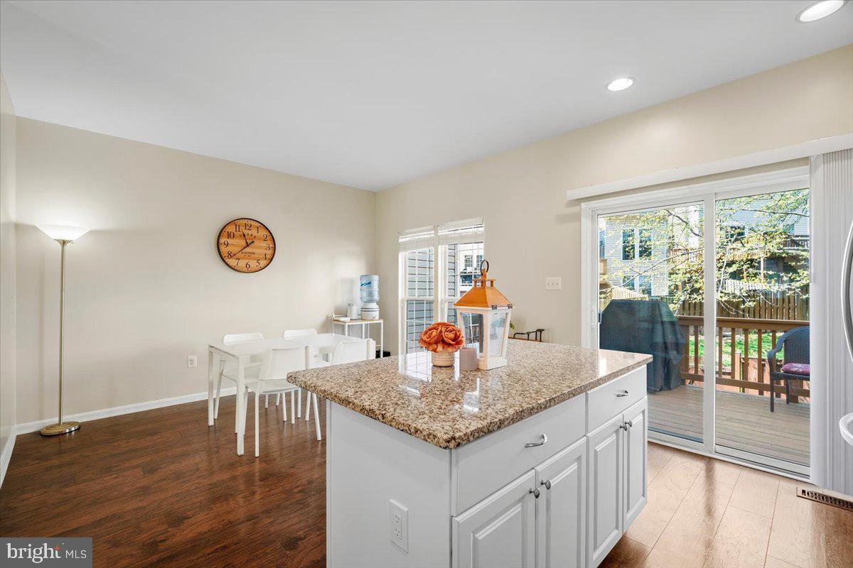 22019 Box Car Square Sterling, VA 20166 - Photo 3 of 31 a kitchen with a table chairs and wooden floor