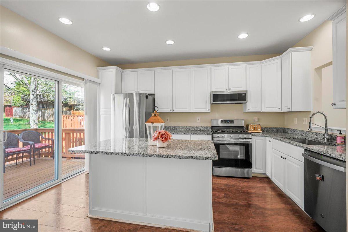 22019 Box Car Square Sterling, VA 20166 - Photo 4 of 31 a kitchen with kitchen island granite countertop a stove sink and cabinets