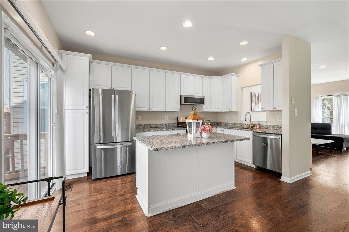 22019 Box Car Square Sterling, VA 20166 - Photo 5 of 31 a kitchen with stainless steel appliances granite countertop a refrigerator stove and wooden floor