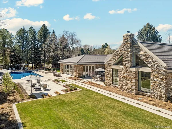 a dining room with wooden floor a chandelier a wooden table and chairs