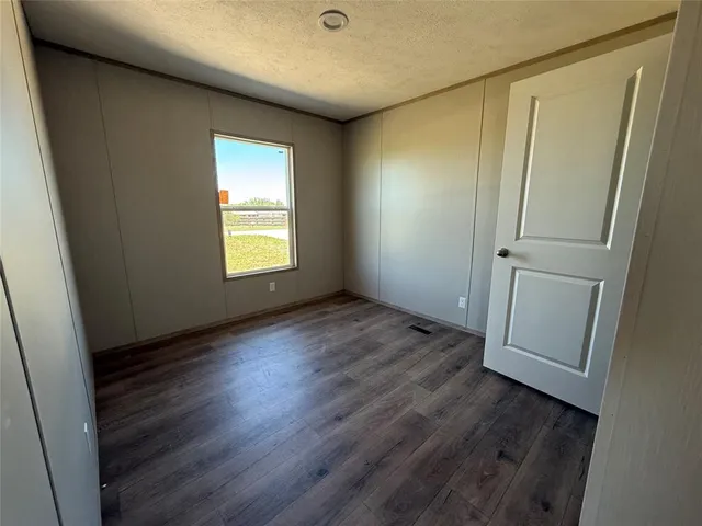 an empty room with wooden floor and window