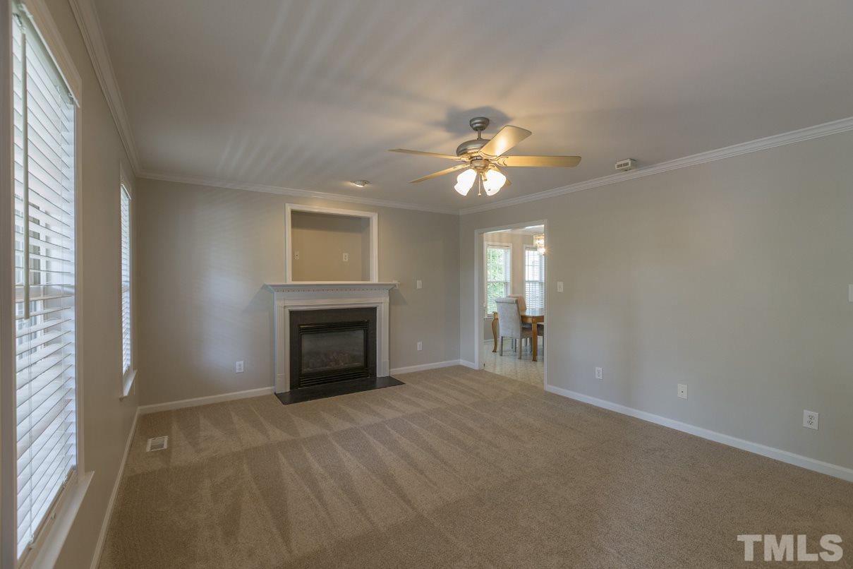 826 Shackleton Road Apex, NC 27502 - Photo 12 of 24 an empty room with windows and a fireplace