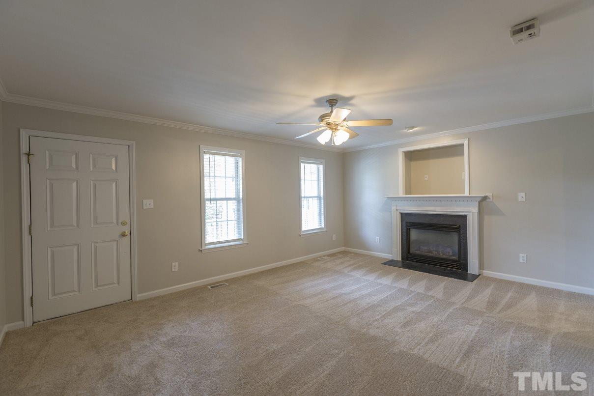 826 Shackleton Road Apex, NC 27502 - Photo 14 of 24 a view of an empty room with a fireplace and fan