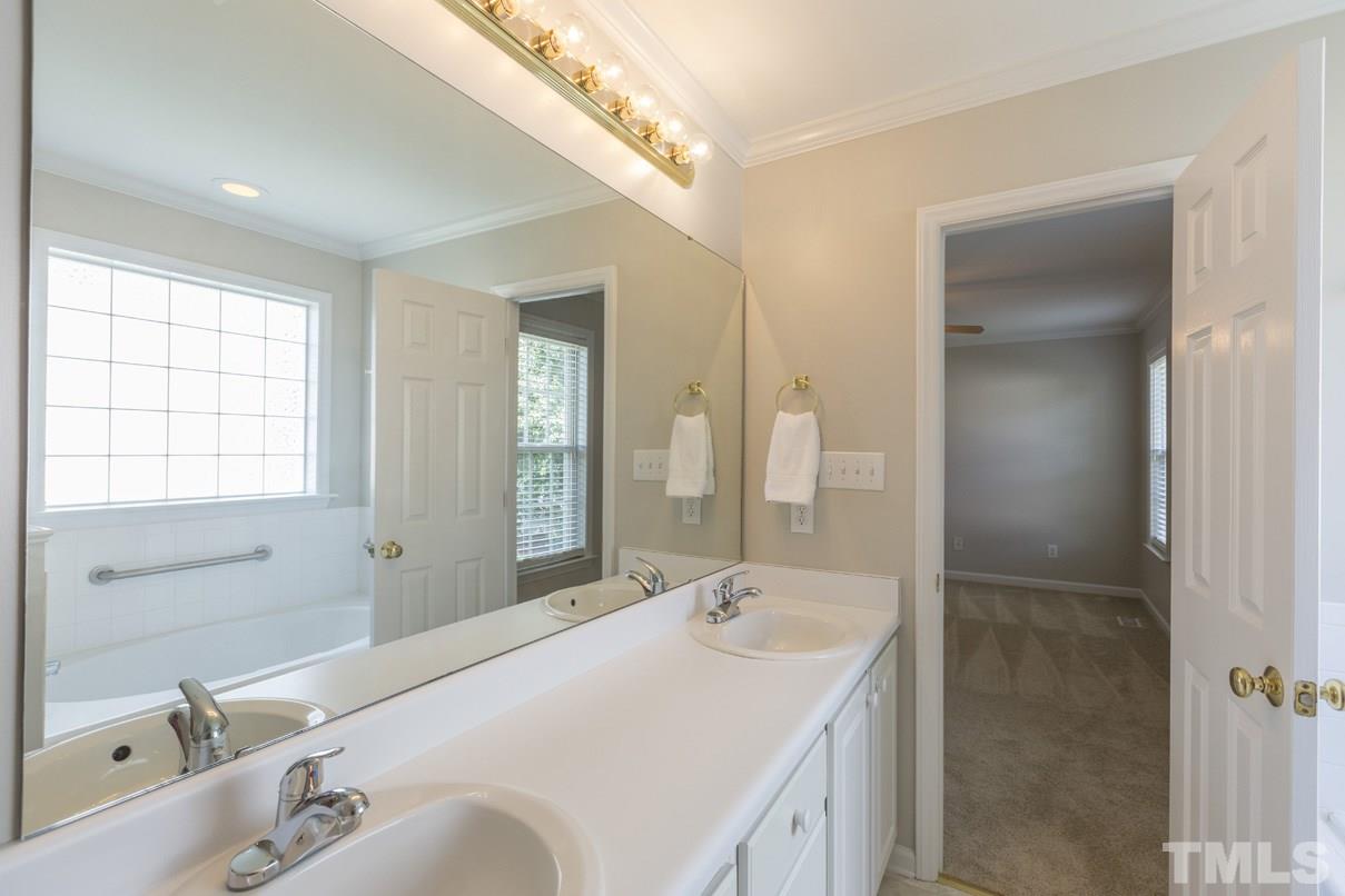 826 Shackleton Road Apex, NC 27502 - Photo 19 of 24 a bathroom with a tub sink and mirror