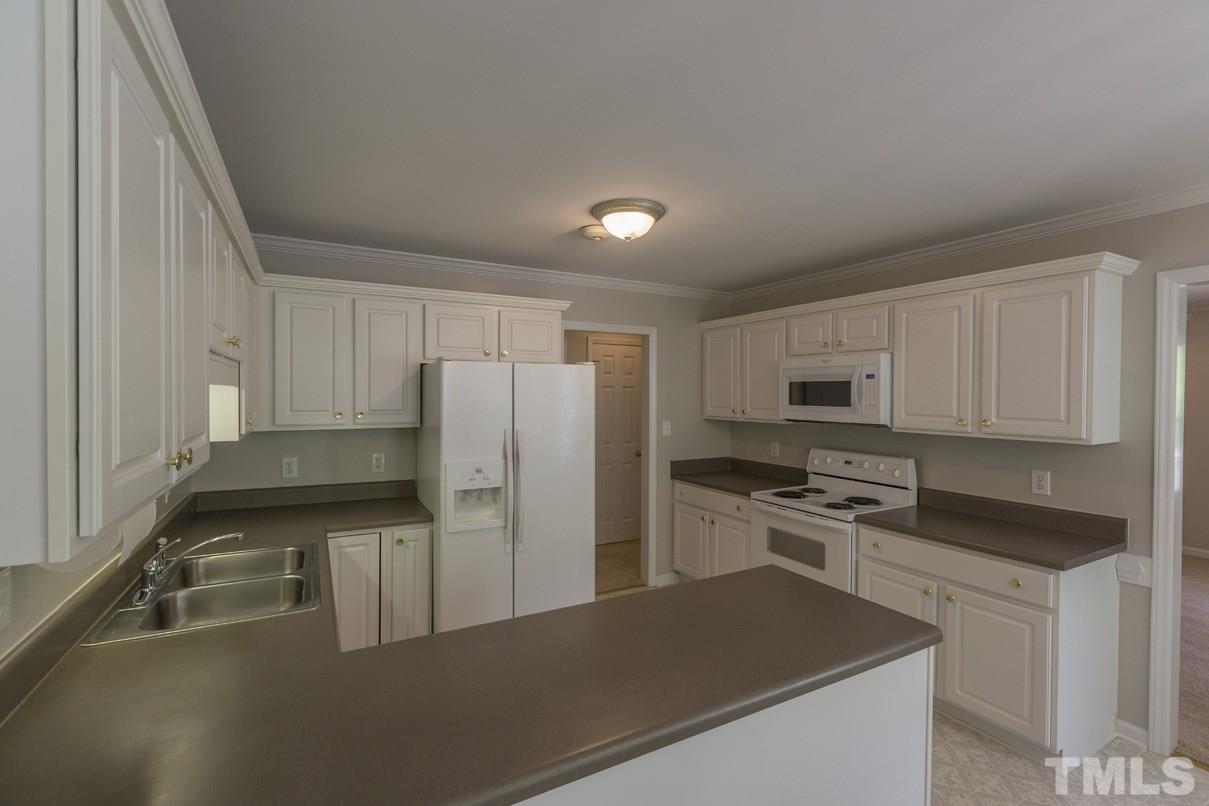 826 Shackleton Road Apex, NC 27502 - Photo 6 of 24 a kitchen with stainless steel appliances a refrigerator stove and sink