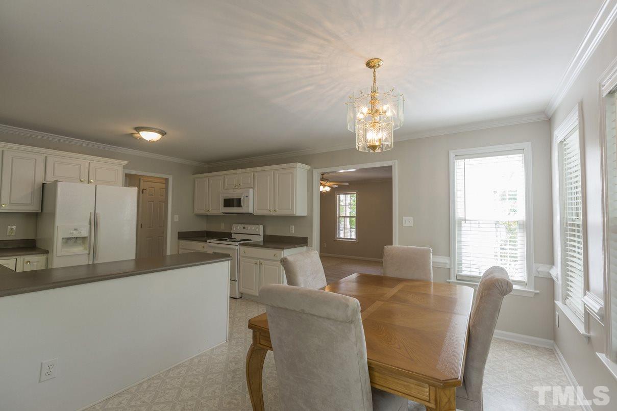 826 Shackleton Road Apex, NC 27502 - Photo 7 of 24 a living room with stainless steel appliances kitchen island granite countertop furniture and a fireplace