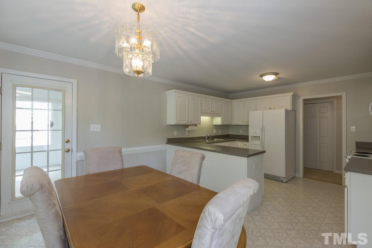 826 Shackleton Road Apex, NC 27502 - Photo 8 of 24 a kitchen with stainless steel appliances granite countertop a stove a refrigerator a sink dishwasher with a dining table and chairs