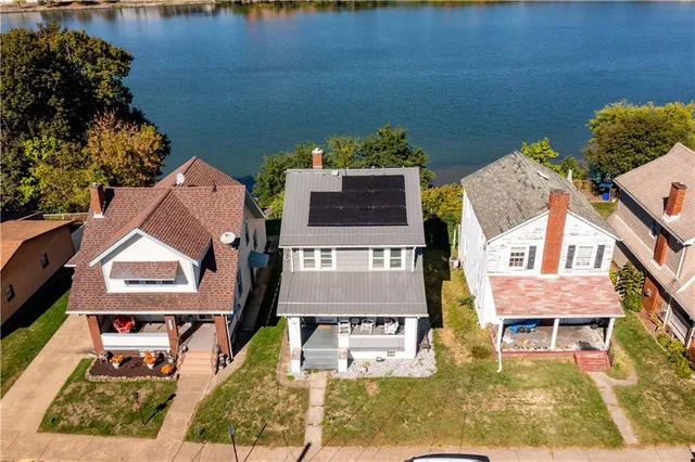 an aerial view of a house with swimming pool and a yard