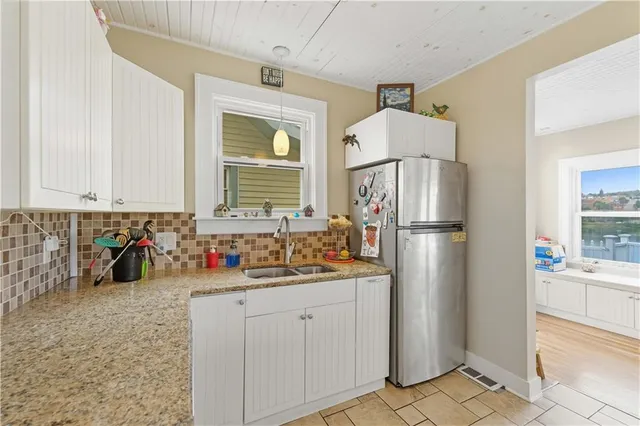a kitchen with white cabinets and refrigerator